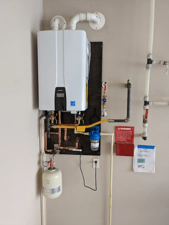 Professional plumber installing copper piping in a Laconia home